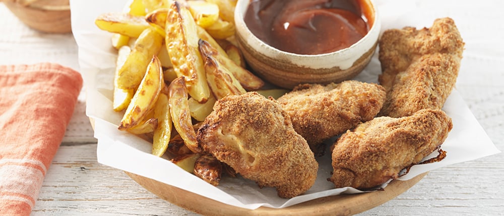 Panierte Chicken Nuggets mit gebackenen Kartoffelschnitzen und Gewürzketchup